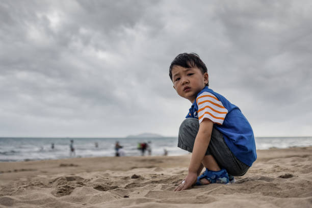 istock Asian boy playing by the sea 1318147724