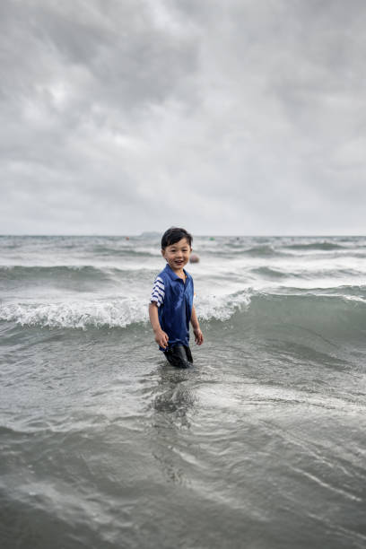 Asian boy playing by the sea