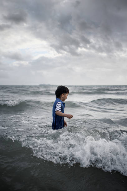 istock Asian boy playing by the sea 1318147760