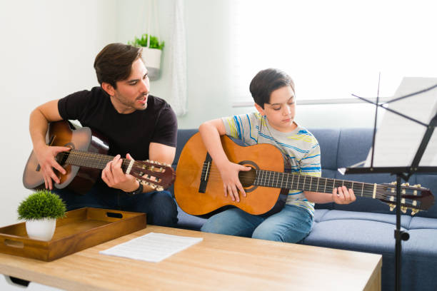 istock Caucasian kid memorizing a new song on the guitar 1318148593
