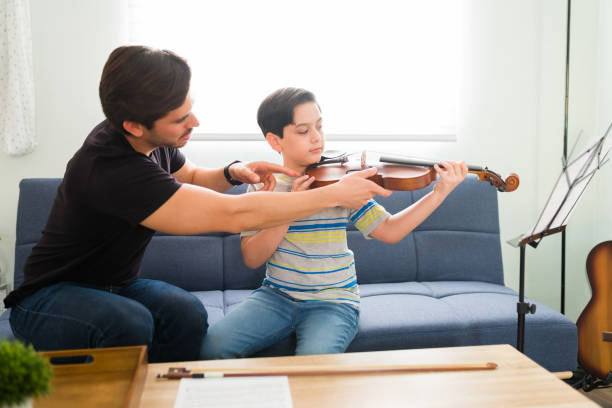 istock Explaining how to play the violin to a student 1318148646