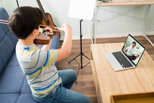 istock Talented boy learning to play the violin online 1318148897