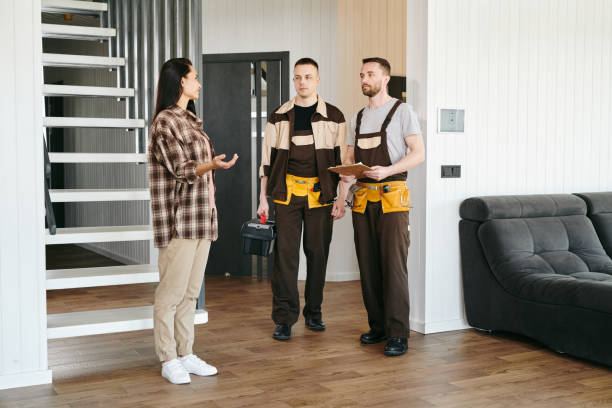 istock Two plumbers and young female having conversation about plumbing problems 1318150308