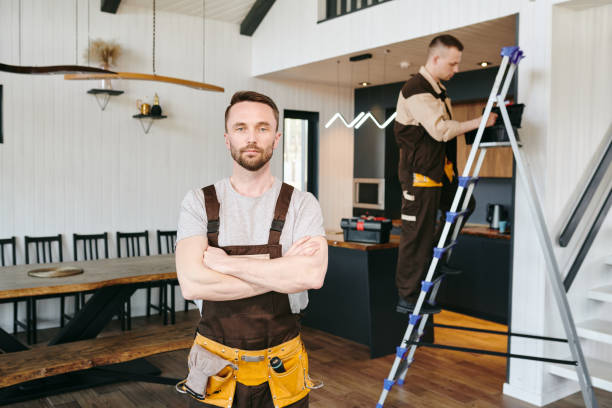 istock Young confident plumber in uniform standing against his colleague 1318150347