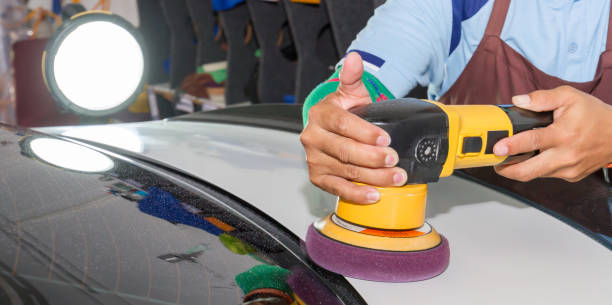 istock Man worker coating white car with wax and tool 1318153457