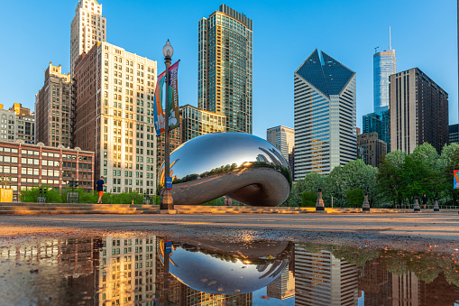 Chicago, IL, USA - May 10, 2018: A pedestrian passes below the Chicago cityscape through Millennium Park in the morning.