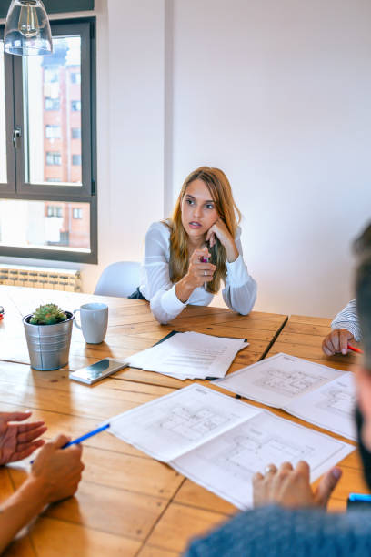 istock Businesswoman in a work meeting looking blueprints 1318155851