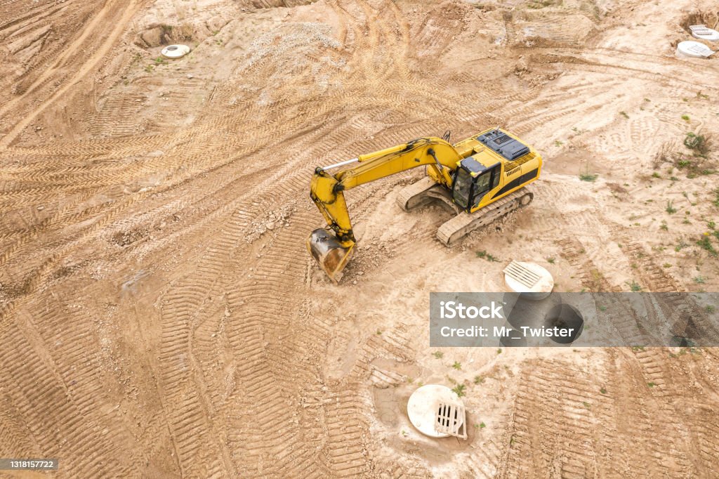 yellow industrial excavator working on construction site. drone point view Construction Site Stock Photo