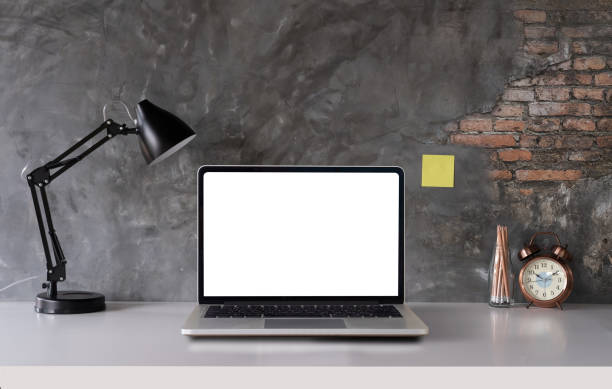 istock White desk with laptop computer blank white screen, lamp, office supplies, clock in design vase 1318158170