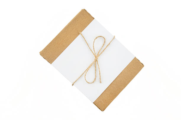 istock A small cardboard box made of corrugated cardboard wrapped with a white sheet and a gray string in a bow, isolated on a white background, top view. 1318159965
