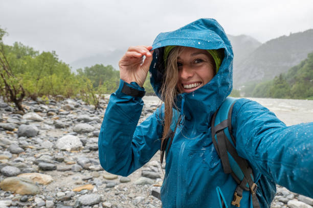 excursionista mujer bajo la lluvia tomar un selfie - lluvia fotos fotografías e imágenes de stock