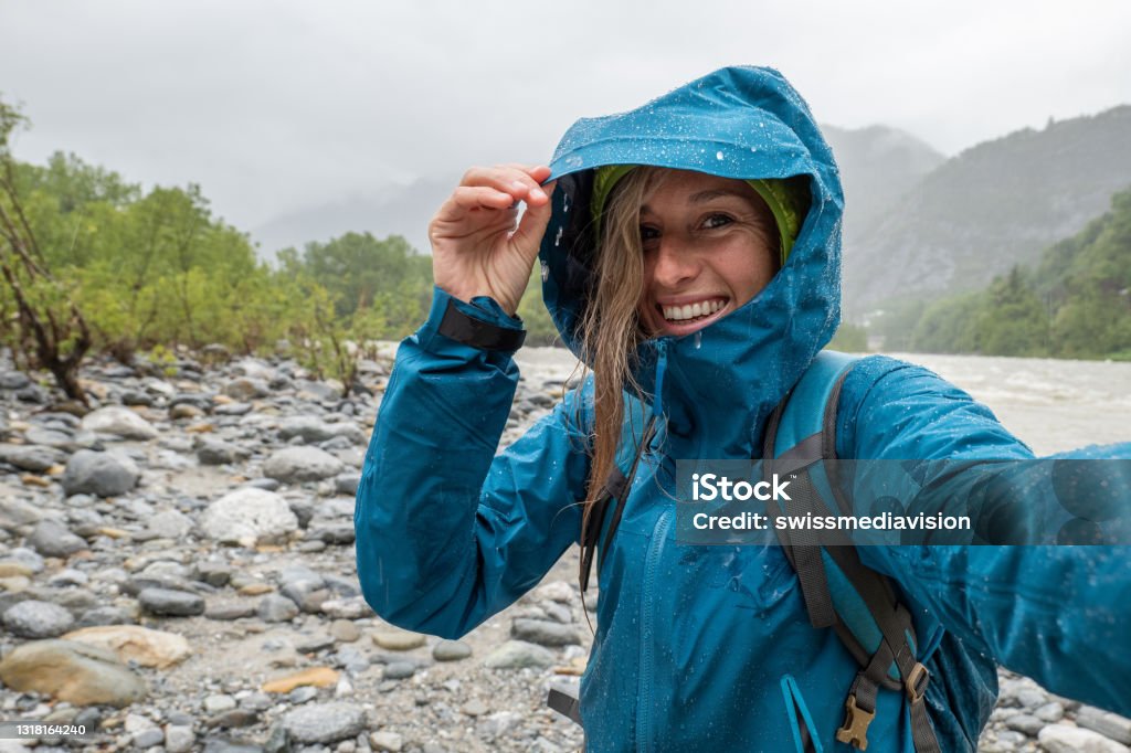 Hiker female under the rain take a selfie She smiles, happy to be under the rain Hiking Stock Photo