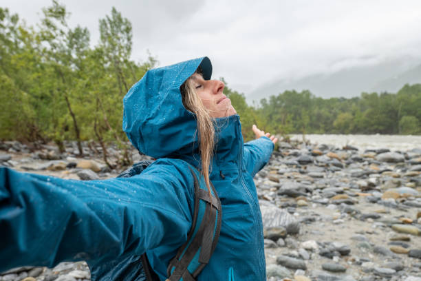 istock Hiker female under torrential rain embraces nature 1318164300