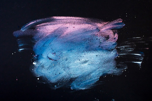 Abstract of coloured make-up powders on black background