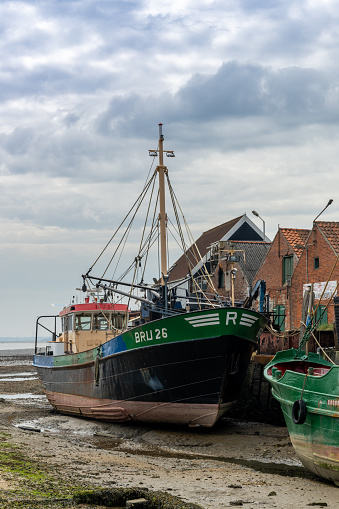 Yerseke, Holland - 13 May, 2021: old fishing boats in the port of Yerseke at low tide