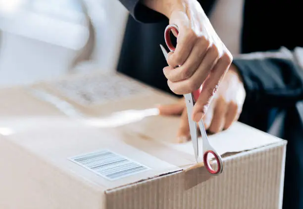 Photo of Close-up of a woman opening her courier parcel