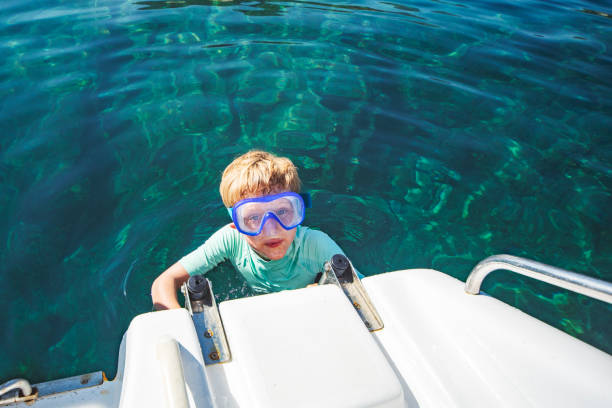 niño pequeño buceando desde lancha rápida - child jumping swimming nautical vessel fotografías e imágenes de stock