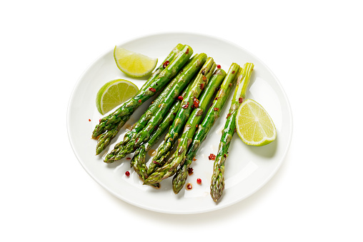 Grilled organic asparagus with lemon on white plate .isolated on white background.