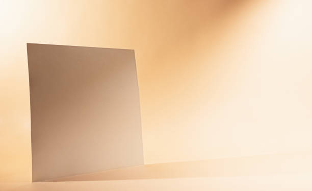 istock Gold Paper sheet or blank card on beige background. 1318174214