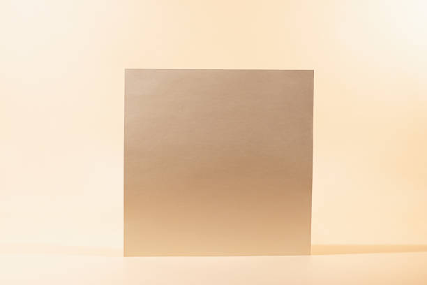 Gold Paper sheet or blank card on beige background.