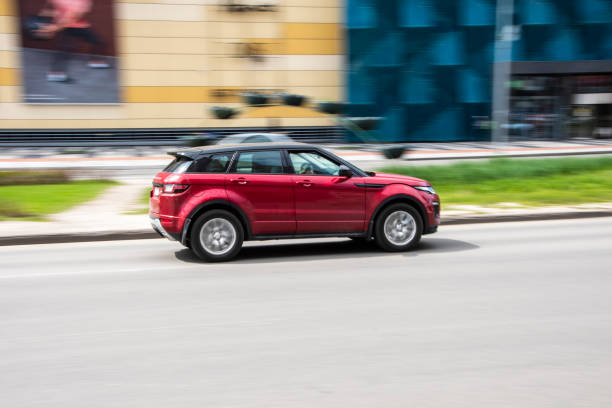 Red Land Rover Range Rover Evoque car moving on the street. Ukraine, Kyiv - 26 April 2021: Red Land Rover Range Rover Evoque car moving on the street. Editorial evoque stock pictures, royalty-free photos & images
