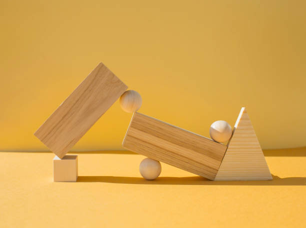 istock Wooden figures balanced on yellow background, room for text. 1318176826