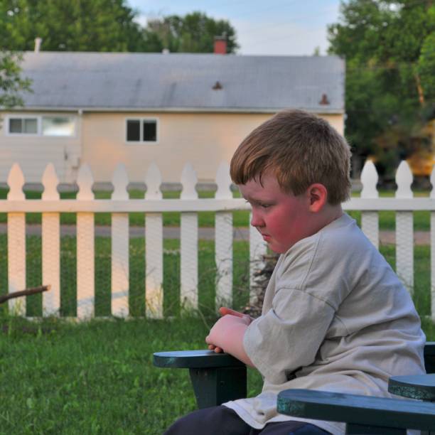 Young Boy with Time Out A 7 year old boy has had his feelings hurt and is undergoing a time out until his attitude improves rosy cheeks stock pictures, royalty-free photos & images