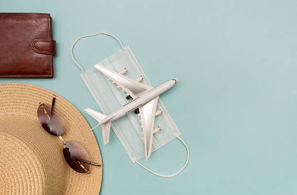 istock Traveling by plane. Mock up on a blue background. Hat, plane, glasses, wallet. 1318181956