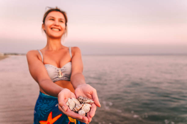 istock Woman holding seashells 1318185194