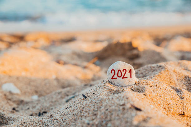istock White stone with the inscription 2021 on a beach 1318187781