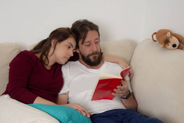 istock parents on the couch reading book 1318188967