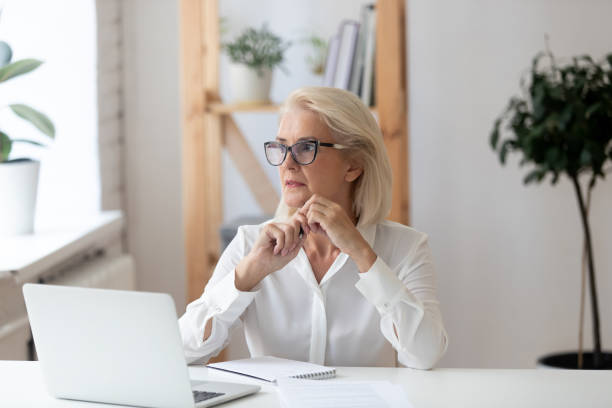 istock Thoughtful 60 years old businesswoman using laptop. 1318189930