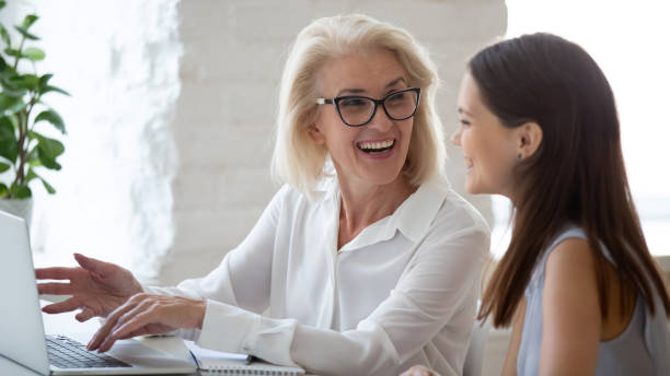 istock Smiling diverse female colleagues brainstorm on laptop 1318189955