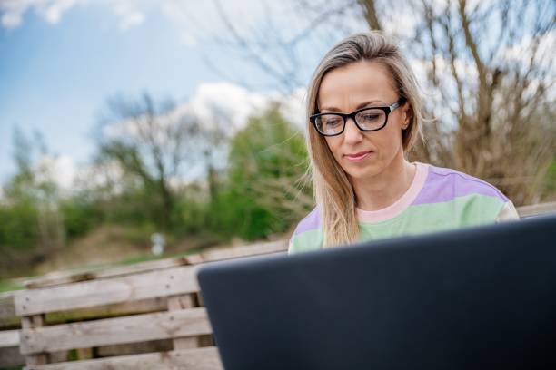 istock Woman with glasses working outside using a laptop. Working outside the office. 1318192108