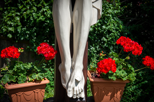 The feet of the crucified Jesus statue are with flowers.