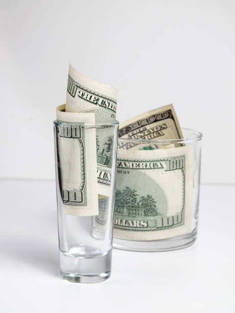 istock 100 dollar bills in a whiskey glass 1318197340