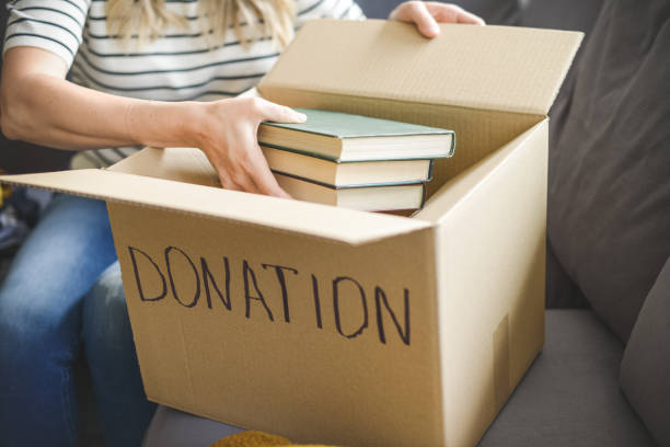 woman puts donations in a box stock photo
