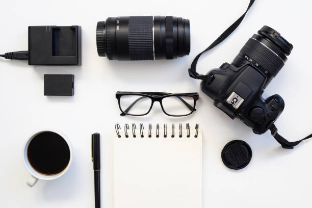 istock top view of work space photographer with digital camera, lens, blank notebook, pencil, glasses, camera accessory with coffee on white table background 1318200330