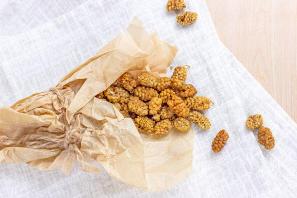 Dried sweet natural mulberry berries on light background in the kitchen.