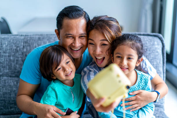 junge mixed rasse asiatische familie bindung zu hause mit einer polaroid-kamera. - polaroid transfer fotos stock-fotos und bilder