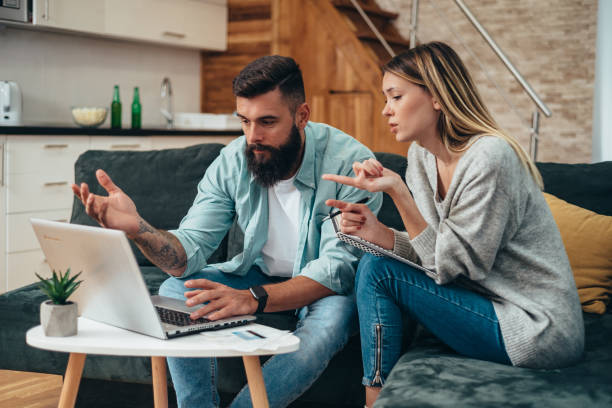 istock Young beautiful couple using a laptop calculating their finances at home 1318204720