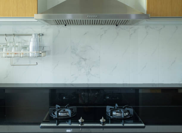 Kitchen corner with marble wall Inside there is a gas stove, glass shelf and hood. stock photo