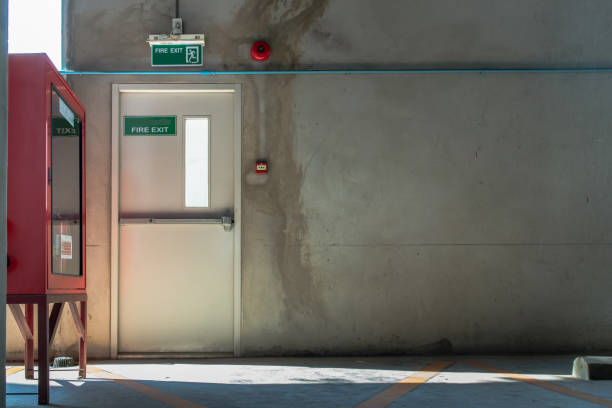 istock Fire exit door or Fire escape door with exit sign and Red fire fighting equipment cabinet in a car parking building. 1318212898
