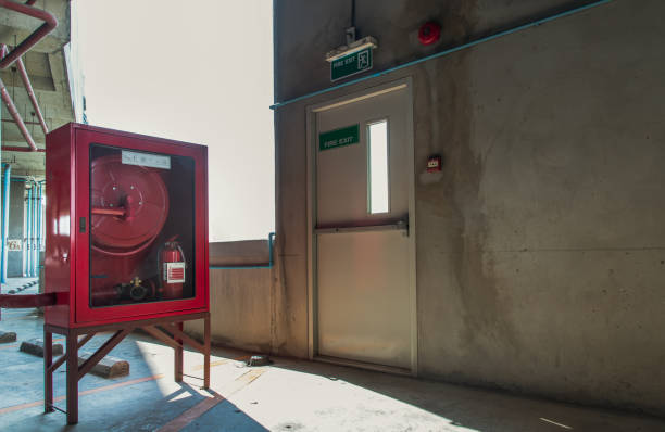 istock Fire exit door or Fire escape door with exit sign and Red fire fighting equipment cabinet in a car parking building. 1318212906