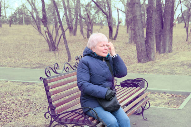 istock Senior Woman Relaxing On Park Bench. Retro filter. 1318222402