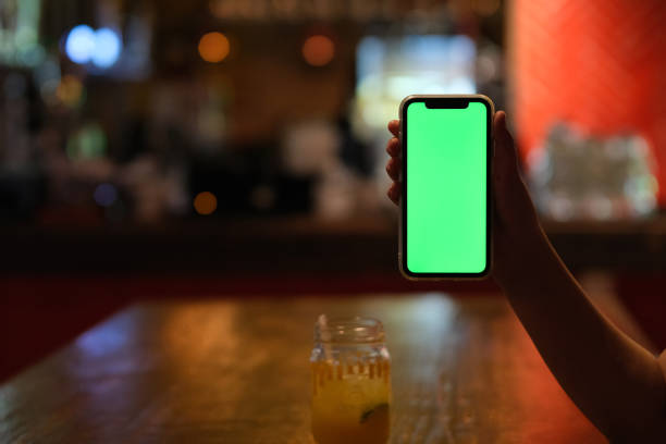 istock hand showing green screen phone at night bar 1318229134