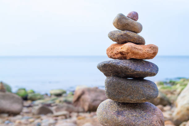 istock Stones pyramid on the seashore. Sunset on pebble beach. Balanced life, relax. 1318234817