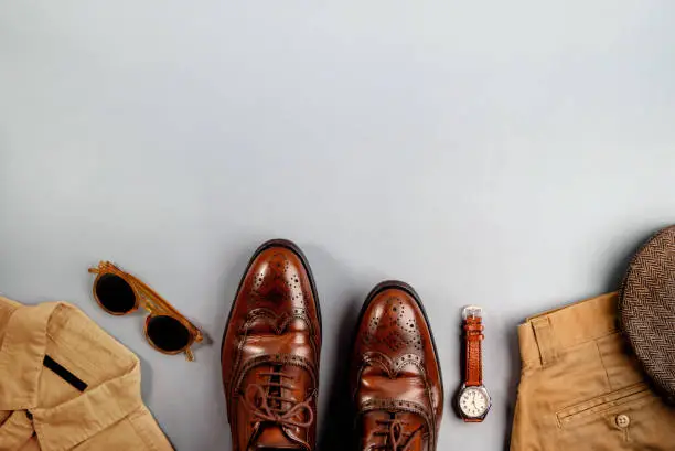 Men Clothes, Father Day Concept. Vintage Style. Flat Lay on Light Grey Background.Included Wingtips Dress Shoes, Hand Watch, Flat Cap Hat, Shirt, Pant and Sunglasses . Stylish Men. Top View