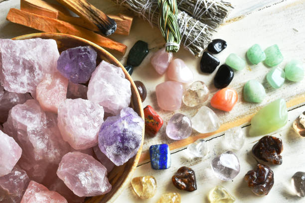 Rose Quartz and Healing Crystals A top view image of a bowl of rose quartz crystals with several other healing crystal and smudge sticks. crystal stock pictures, royalty-free photos & images