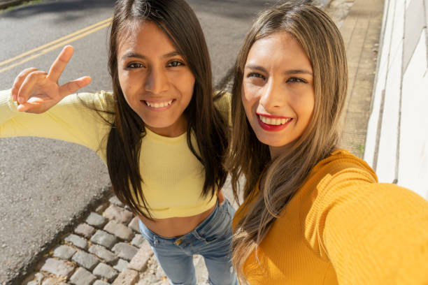 istock Two beautiful young women laughing while taking a selfie with their cell phone. Technology, communications, joy and friendship concept. 1318238820
